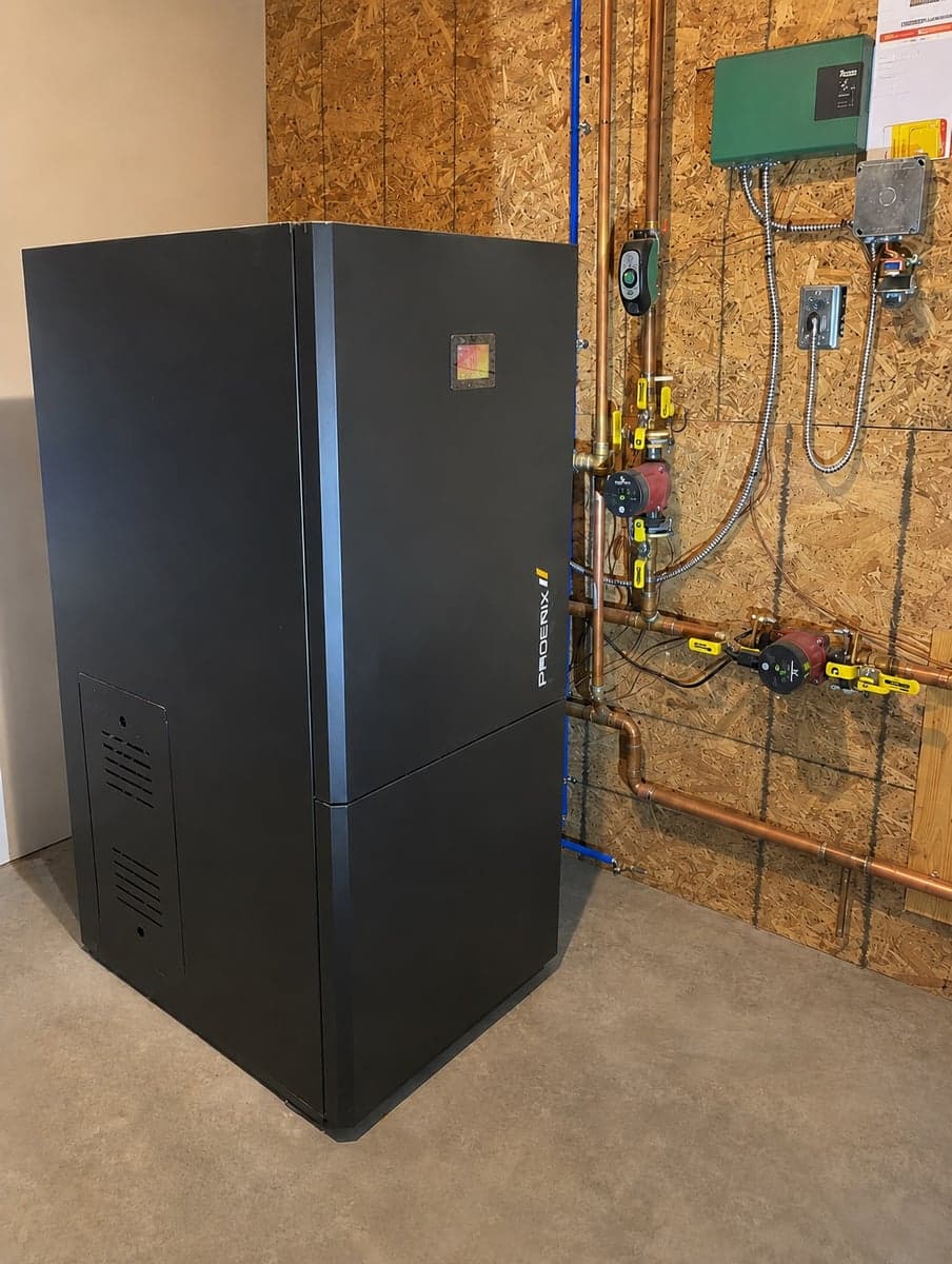 Phoenix boiler installed in a mechanical room with copper hydronic piping, pumps, and controls.