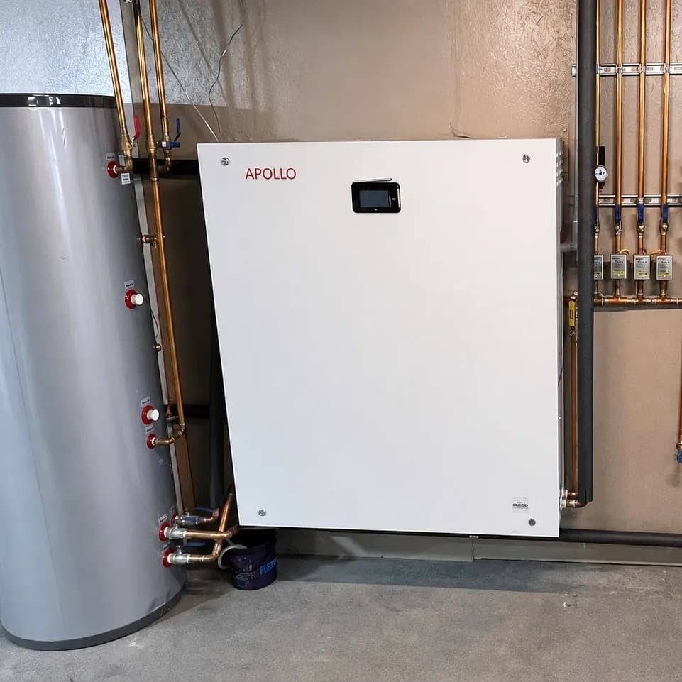 Square crop of an Apollo hydro station installed beside a buffer tank and copper piping.